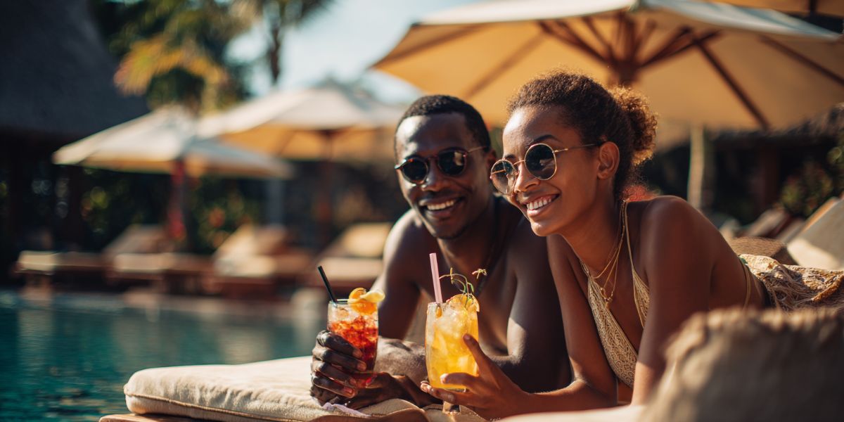 Vacation Purists lying next to the pool drinking cocktails